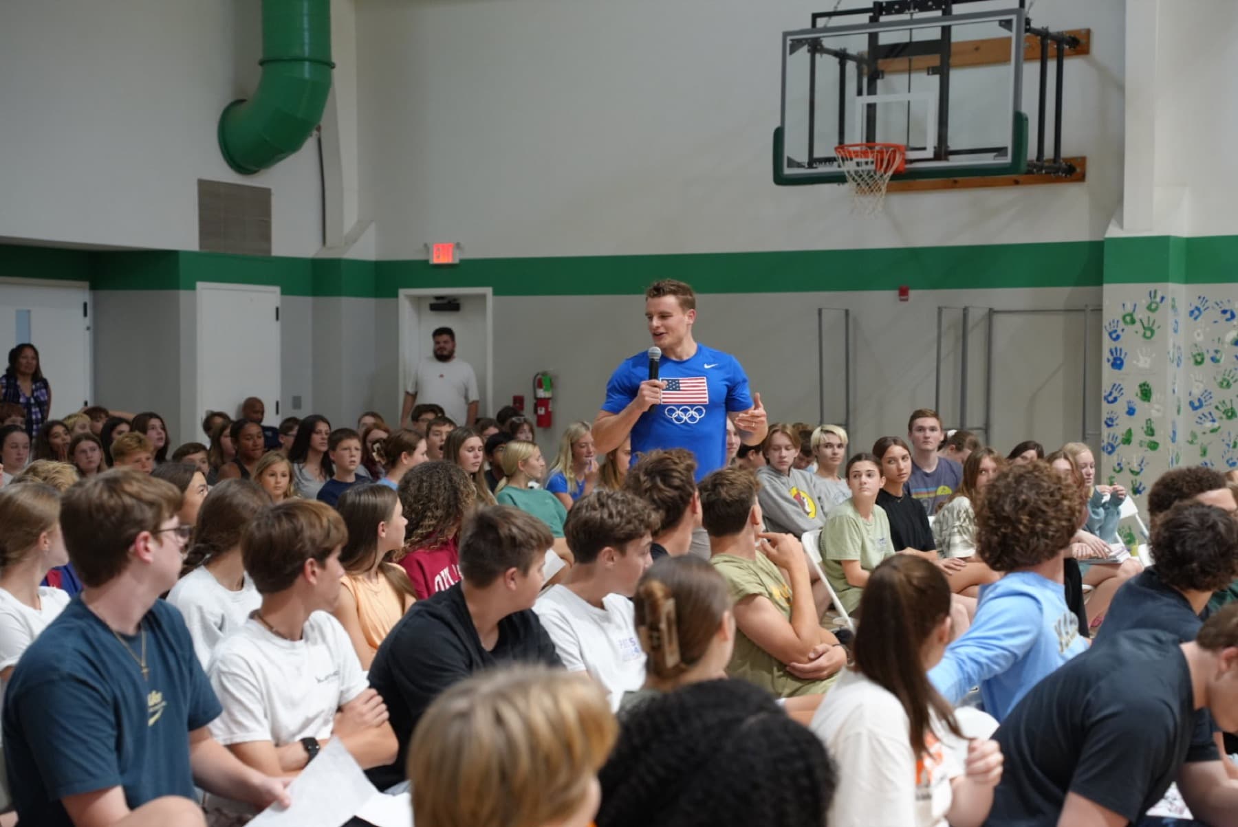 Nate Roy speaking to a gym full of student-athletes