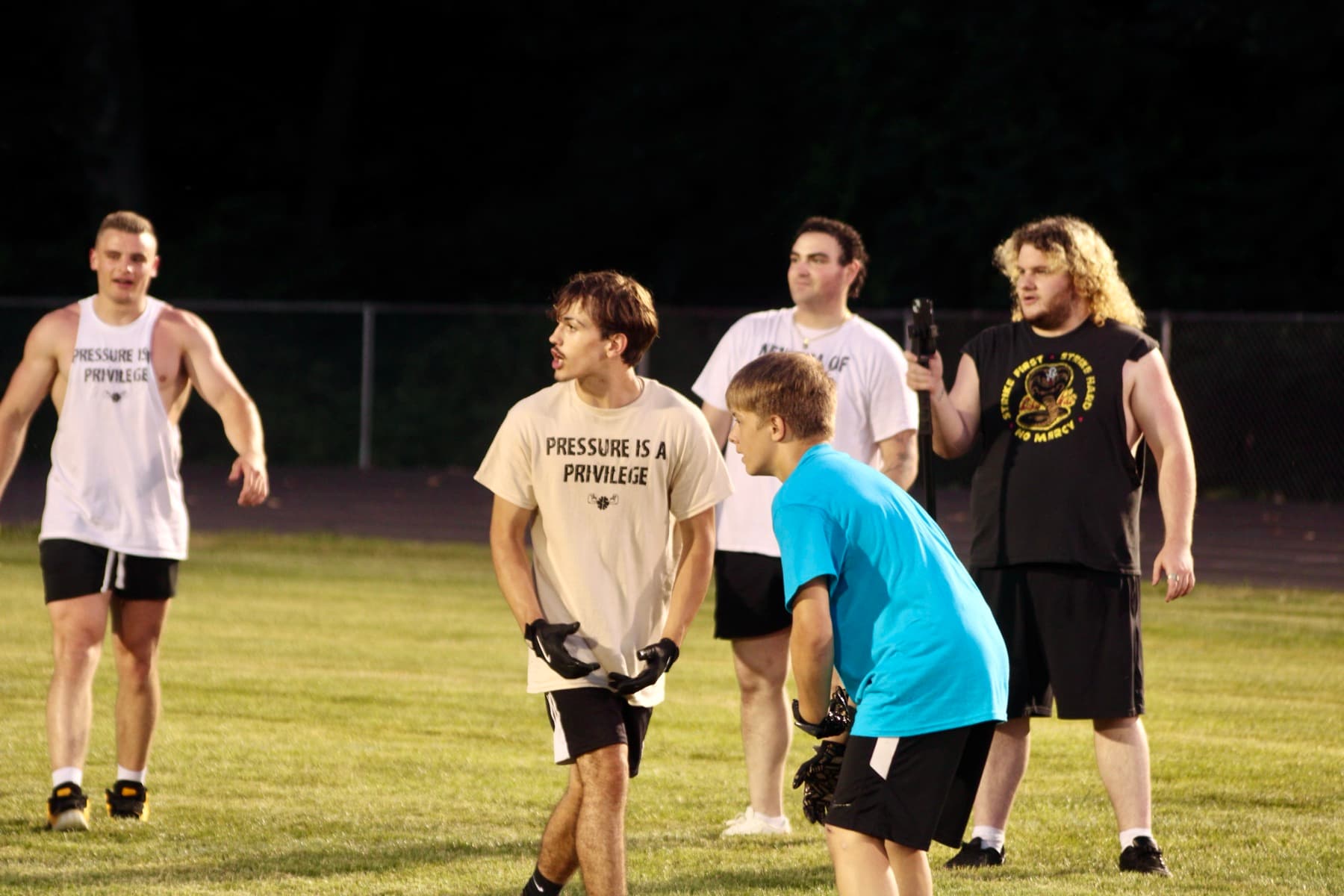 Athletes and coaches on the field at an evening session